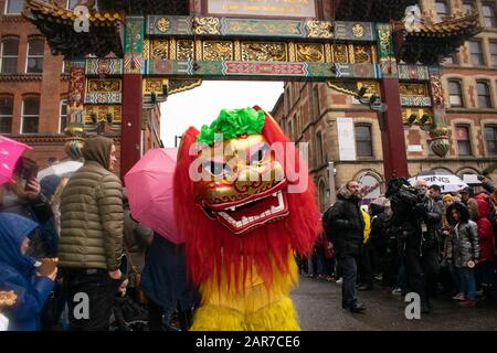 Capodanno cinese Manchester UK con balli di leone davanti all'arco cinese a Chinatown e folla di persone sullo sfondo Foto Stock