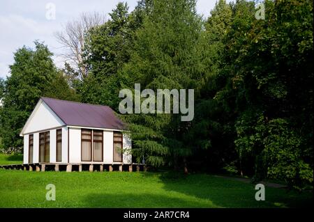 piccola casa bianca con finestre drappeggiate su un piccolo pendio, spazio copia Foto Stock