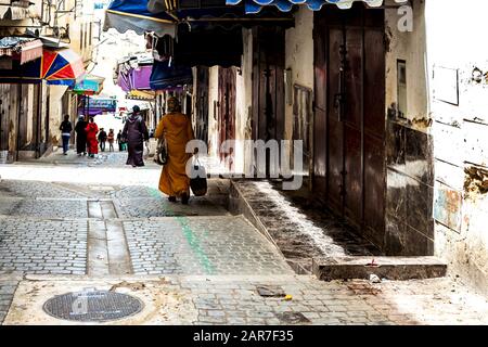 Fes, Marocco - 21,04, 2019: Persone che camminano nella strada del bazar del mercato all'aperto a Fez. Tradizionali negozi del nord africa, con stuf artigianale Foto Stock