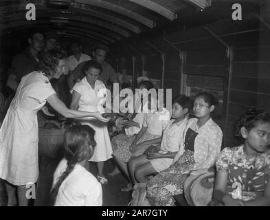 Arrivo treno di evacuazione della Croce Rossa KNIL Con treno supplementare, famiglie di soldati TNI sono stati trasportati a Gombong e trasferiti lì ad una delegazione repubblicana, che si è presa cura di ulteriori trasporti. Con lo stesso treno, le famiglie di soldati KNIL ritornarono dalla repubblica. La cura era nelle mani della Croce Rossa Batavia. Dinnertime sul treno. Data: 22 Maggio 1948 Luogo: Gombong, Indonesia, Java, Indie Orientali Olandesi Foto Stock