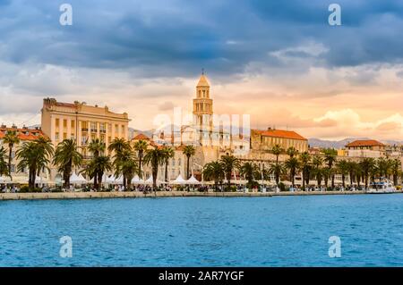 Spalato, Croazia - 21 maggio 2019: Città vecchia divisa con la Cattedrale di San Doimo, edifici colorati, Riva Promenade e palme. Vivida evenin fronte mare Foto Stock