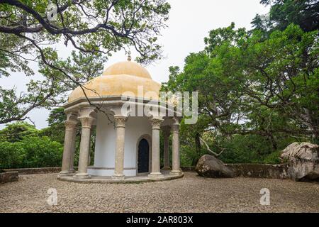Tempio delle colonne, un antico e piccolo tempio in un lussureggiante e verdeggiante parco naturale al Parco pena che circonda il Palazzo pena di Sintra, Portogallo. Foto Stock