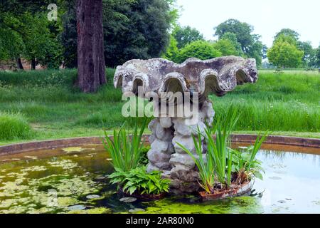 Pietra acqua caratteristica in un giardino stagno sul bordo della campagna inglese rurale, Cotswolds, Regno Unito. Foto Stock