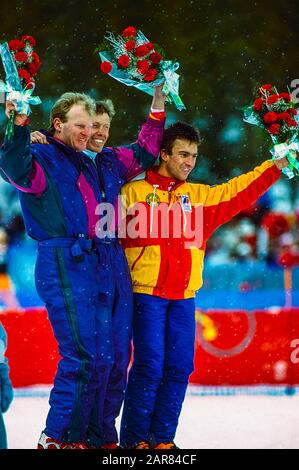 Pirmin Zurbriggen della Svizzera (C) vince la medaglia d'oro in discesa, Peter Müller (sui) -L- Silver, Franck Piccard. (Fra) -R- Bronzo ai Giochi Olimpici invernali del 1988. Foto Stock