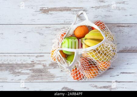 Sacchetto in cotone a rete per alimentari con frutta e verdura. Zero sprechi, nessun shopping di plastica. Concetto di stile di vita sostenibile. Riciclaggio. Foto Stock