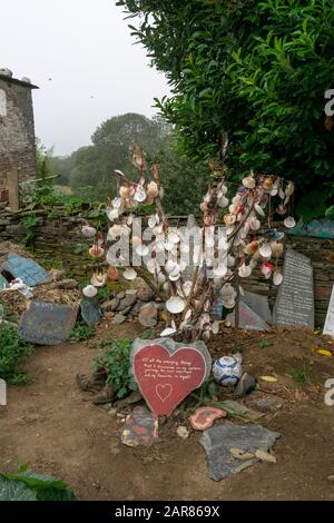 Conchiglie attaccate a bastoni in un giardino di cottage di campagna lungo il Camino de Santiago Foto Stock