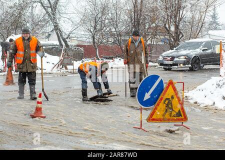 Città del servizio di emergenza di riparazione rottura tubo acqua in inverno. Foto Stock