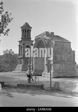 Viaggio in Francia Saint-Remy-de-Provence. La città romana rovina di Glanum: A destra un arco trionfale con dietro di esso la tomba della famiglia Iulii; in primo piano fotografo Van de poll con bicicletta Data: Settembre 1935 posizione: Francia, Saint-Remy-de-Provence Parole Chiave: Archeologia, architettura, biciclette, fotografi, memoriali, mausolei, monumenti, porte Nome personale: Sondaggio, William van de Foto Stock