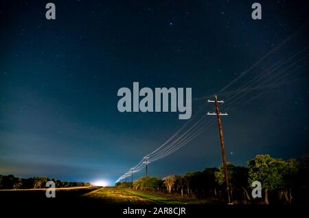 Strada Di Campagna Illuminata Dal Traffico Nella Notte Con Stelle Su Cielo Trasparente Foto Stock