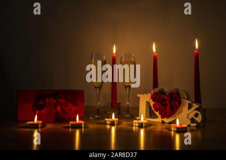 Foto notturna di candele accese e bicchieri da champagne Foto Stock