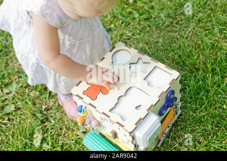 La ragazza inserisce una figurina dell'orso nel foro delle risorse di apprendimento cubo di smistamento, giocattolo del motore fine, numero iniziale, Modelli. Sviluppo di giochi per bambini. Occupato Foto Stock