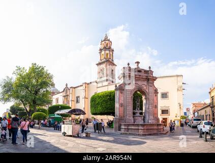 Santiago de Queretaro, Queretaro, Messico - 24 novembre 2019: Vista su Francisco i Madero, con persone che camminano vicino alla fontana di nettuno, Tempio Di Lif Foto Stock