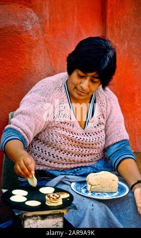 Usando una stufa piccola, una donna messicana cuoce pazientemente le tortillas fresche su un marciapiede di Città del Messico. Nota cubo di pasta. Foto Stock