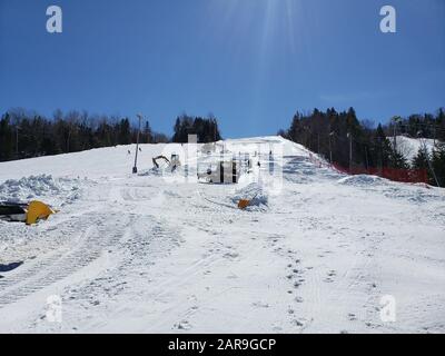 Saint-Sauveur, Canada - 11 aprile 2019: Macchina per la cura della neve in una soleggiata giornata primaverile. Sommet Saint Sauveur è una stazione sciistica di Quebec con un sacco di piste, Foto Stock