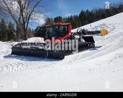 Saint-Sauveur, Canada - 11 aprile 2019: Macchina per la cura della neve in una soleggiata giornata primaverile. Sommet Saint Sauveur è una stazione sciistica di Quebec con un sacco di piste, Foto Stock