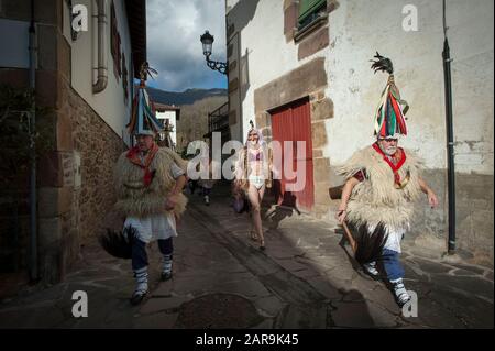 Joaldunaks sfilano attraverso le strade durante il carnevale.Il suono delle campane si sente attraverso la valle Bidasoa, Ituren un piccolo villaggio situato nella regione di Malerreka, presages l'accoglienza dei carnevali tanto attesi per tutti gli abitanti della regione. I Joaldunaks camminano per le strade vestite di sandali, petticavene sulla punta del piede, pelli di pecora sulla vita e sulle spalle, sciarpe colorful del collo, ttuntturroa (cappelli affusolati) e un bastoncino di cavallo sulla loro mano destra, suonano le loro campane facendo il loro suono rumble in tutta la valle, così guidando via gli spiriti maligni. Foto Stock