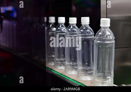 Cancellare le bottiglie di plastica trasferire sul trasportatore automatizzato di sistemi di automazione industriale per il pacchetto Foto Stock