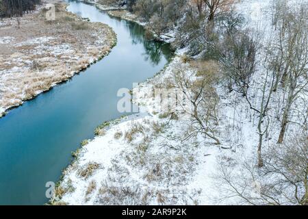 vista aerea del fiume e degli alberi in inverno con neve appena caduta. freddo inverno Foto Stock