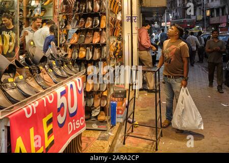 Un uomo degli strati inferiori della società indiana che staring ad un negozio di scarpe in Kalbadevi Road, Bhuleshwar, Mumbai, India Foto Stock