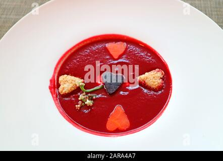 Zuppa di barbabietole con Verdure A Forma Di Cuore in Un Piatto bianco Foto Stock
