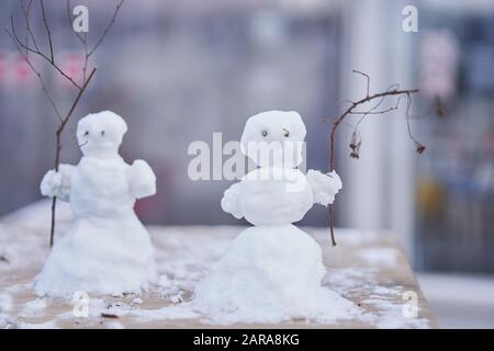 Due piccoli pupazzo di neve carino con rami invece di mani sfondo di Natale nuovo anno umore. Foto Stock