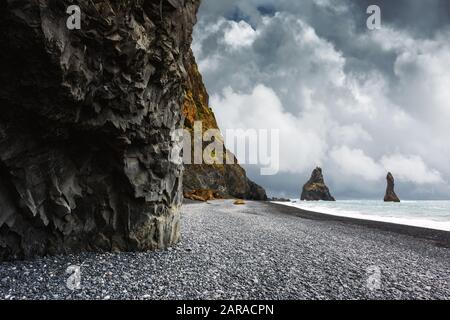 Formazioni rocciose di basalto Troll Troll Troll punta sulla spiaggia nera vicino a Reynisdrangar, Vik, Islanda. Fotografia di paesaggio Foto Stock