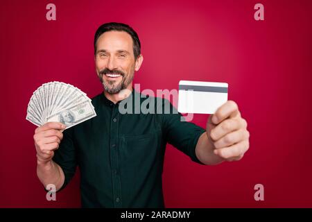 Primo piano ritratto del suo lui bella barbuto uomo tenuta in mano che ti dà libero ritiro carta di plastica isolato su brillante brillante luce brillante Foto Stock