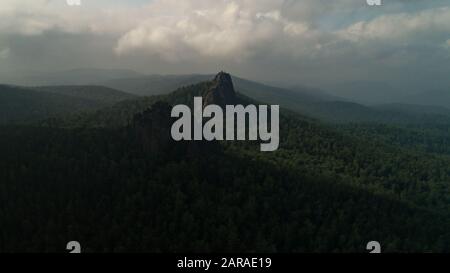 Enormi colonne di pietra dalla montagna. Arancione mattina sole. Deriva del volo del drone dell'antenna cinematografica. Bellissima natura russa Foto Stock