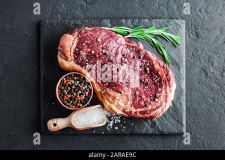 Bistecca di ribeye marmorata su lavagna a ardesia. Costolette di manzo di prima qualità. Fotografia di cibo Foto Stock