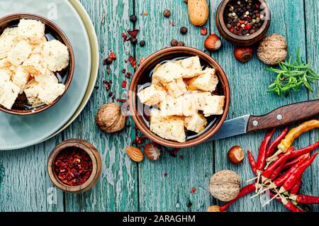 Il formaggio Feta con spezie e aglio sul vecchio sfondo di legno Foto Stock