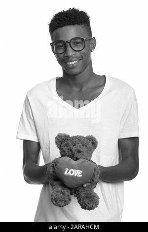 Studio scatto di giovane bell'uomo africano con capelli afro isolato su sfondo bianco in bianco e nero Foto Stock