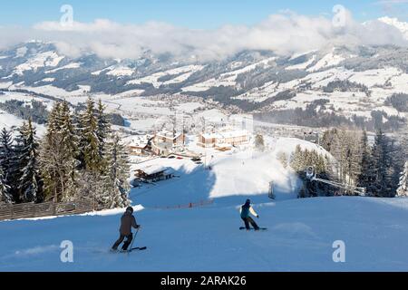 Sciatore e snowboarder sulle piste di Kirchberg in Tirol, parte del comprensorio sciistico di Kitzbühel in Austria. Foto Stock