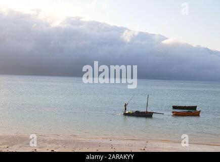 pescatori che navigano sulla nave con un lungo bastone di legno Foto Stock