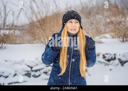 La donna era molto gelata in inverno sotto la neve. Problemi invernali Foto Stock