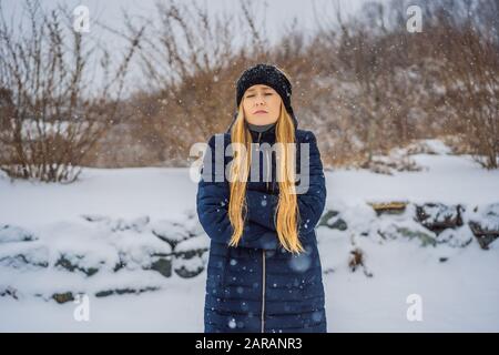 La donna era molto gelata in inverno sotto la neve. Problemi invernali Foto Stock