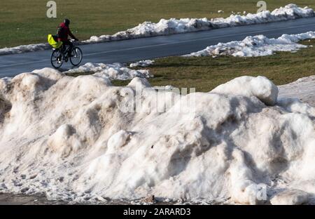 Dresda, Germania. 27th Gen 2020. Una donna ciclista fa un giro lungo il percorso ciclabile dell'Elba sulla Königsufer tra i resti di neve artificiale che è stata lasciata indietro dalla Coppa del mondo di sci. Credito: Robert Michael/Dpa-Zentralbild/Dpa/Alamy Live News Foto Stock