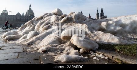 Dresda, Germania. 27th Gen 2020. Una donna ciclista fa un giro lungo il percorso ciclabile dell'Elba sulla Königsufer tra i resti di neve artificiale che è stata lasciata indietro dalla Coppa del mondo di sci. Credito: Robert Michael/Dpa-Zentralbild/Dpa/Alamy Live News Foto Stock