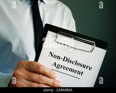 Accordo di non divulgazione per la firma in mano al dipendente. Foto Stock