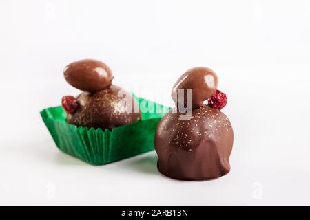 Praline di cioccolato con nocciole e ribes su sfondo bianco Foto Stock