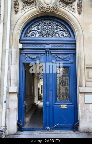 Vecchia porta ornata a Parigi, Francia - tipico vecchio edificio di appartamenti. Foto Stock