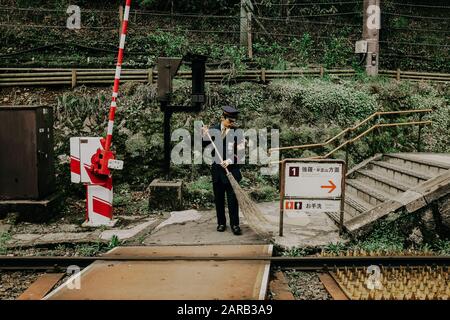 Ogni giorno Street scena in Giappone. L'uomo sta spazzando il sentiero Foto Stock