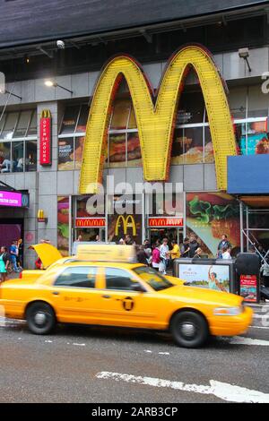 New YORK, Stati Uniti d'America - 10 GIUGNO 2013: La cabina gialla guida lungo Il ristorante fast food Di Times Square McDonald's a New York. Foto Stock