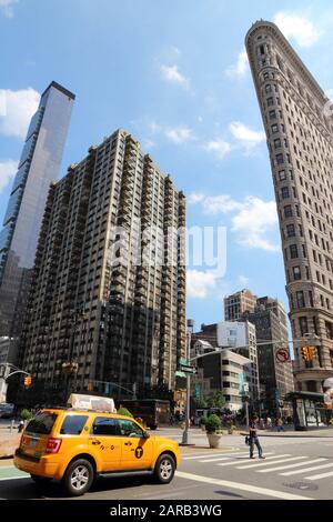 New YORK, USA - 5 LUGLIO 2013: La cabina gialla guida sotto il Flatiron Building di New York. Flatiron è uno degli edifici più riconoscibili di NY ed è c. Foto Stock