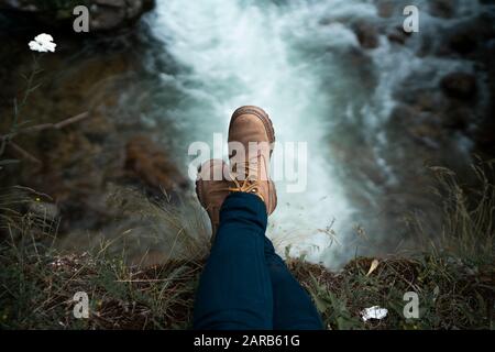 Un colpo delle gambe della ragazza con cascata sullo sfondo Foto Stock