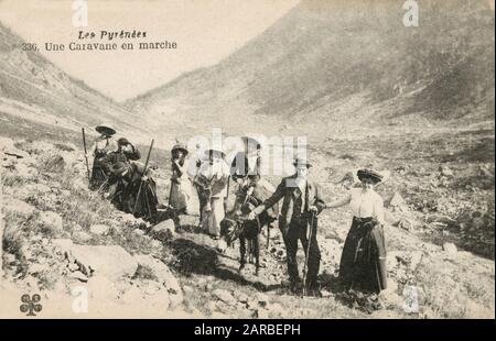 Un grande gruppo familiare ha attraversato una valle nei Pirenei con un asino e alcuni robusti bastoni da passeggio. Foto Stock