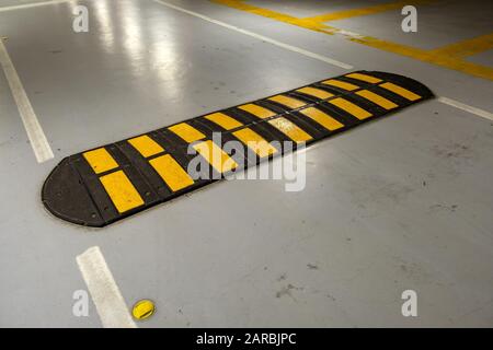 Urto rapido nero e giallo a strisce su strada. Foto Stock