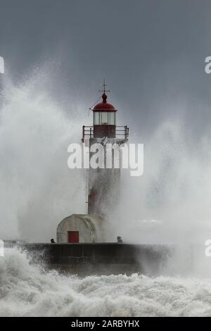 Porto, Portogallo - 7 Febbraio 2016: persone negligente nel mezzo della tempesta di mare. Fiume Douro bocca vecchio faro. Foto Stock