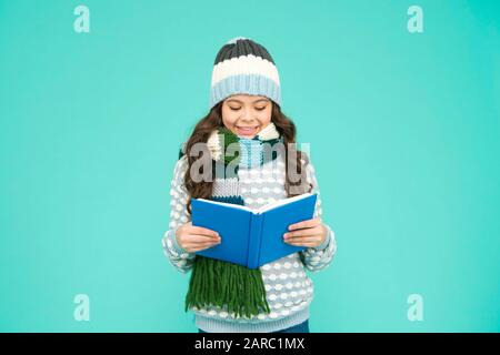 Libro per la lettura della ragazza. Bambino che ama il suo libro. Lettura della storia invernale. Vigilia di Natale. Piccolo amante del libro. Concetto accogliente e confortevole. La mia storia preferita. Tempo libero in inverno. Sviluppo infantile. Foto Stock