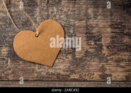 Etichetta marrone a forma di cuore su sfondo di legno. Vista dall'alto dello spazio di copia Foto Stock