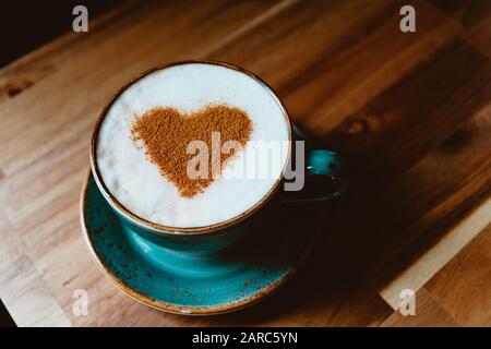 Tazza di cappuccino caffè decorato simbolo cuore cannella. Il concetto di San Valentino giorno e mattina. Foto Stock